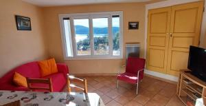 サント・クロワ・デュ・ヴェルドンにあるL'amourié, Rdc, Gîte 4 Personnesの椅子2脚とテレビのあるリビングルーム