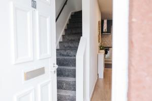 a staircase in a home with a white door at 3BR House By MyStayUK Short Lets & Serviced Accommodation Manchester With Free Wifi & Free Parking in Manchester