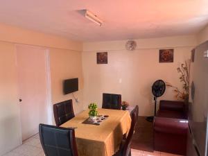 een eetkamer met een tafel met stoelen en een televisie bij Mountain View Apartments in Gros Islet