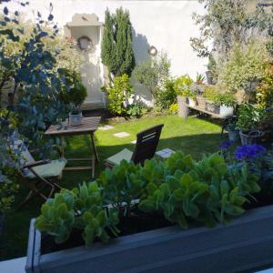 a garden with a table and chairs and plants at Le Clos des Mouettes in Calais +48 photos