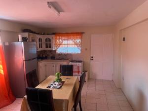 een keuken met een tafel met stoelen en een koelkast bij Mountain View Apartments in Gros Islet