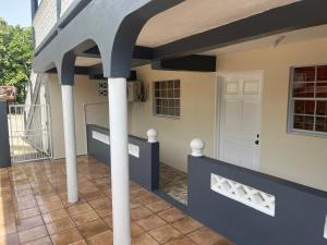 een huis met een veranda met witte zuilen bij Mountain View Apartments in Gros Islet