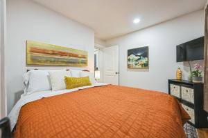 a bedroom with a bed with an orange blanket at Charming Cabin with Hot Tub, Fireplace, Fire Pit, 2 minutes to downtown in Ellijay