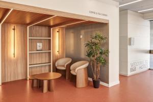 una sala de espera con taburetes y una mesa en B&B HOTEL Granada Estación, en Granada