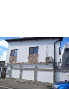 una casa blanca con una valla delante en Garsoniere, en Târgu Jiu 15 fotos más