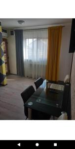 Una habitación con una mesa y sillas y una ventana. en Garsoniere, en Târgu Jiu