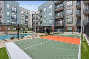 a tennis court in front of an apartment building at Cozy, Charming, and Chic Stay in Dallas