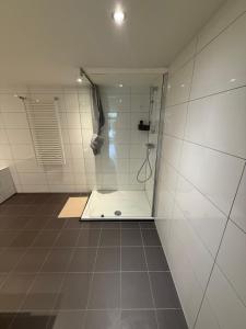 une douche avec une porte vitrée dans une salle de bain dans l'établissement Woonhuis 170m2 Rotterdam Centrum, à Rotterdam 19 autres photos