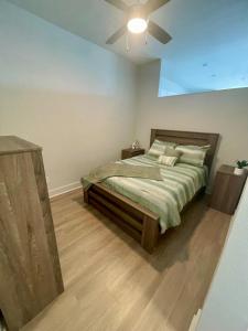 een slaapkamer met een bed met een plafondventilator bij Cozy, Charming, and Chic Stay in Dallas