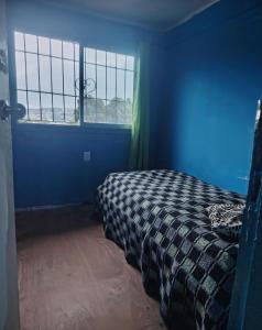 Habitación azul con cama y ventana en Cabaña Marina 1530, en Viña del Mar