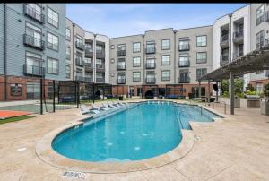 a large swimming pool in front of a building at Cozy, Charming, and Chic Stay in Dallas