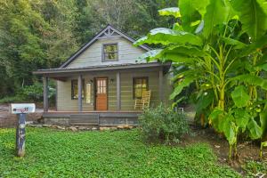 a small house in the middle of a yard at Charming Cabin with Hot Tub, Fireplace, Fire Pit, 2 minutes to downtown in Ellijay