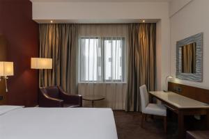 a hotel room with a bed and a desk and a window at Radisson Blu Hotel, Addis Ababa in Addis Ababa