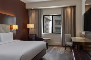 a hotel room with a bed and a desk and a window at Radisson Blu Hotel, Addis Ababa in Addis Ababa