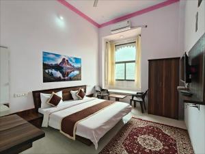 a bedroom with a bed and a desk and a television at The Jaigarh Palace Kumbhalgarh in Kumbhalgarh