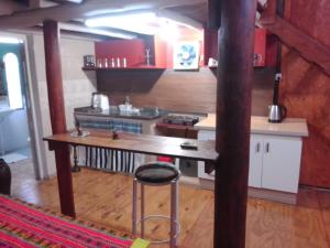 a kitchen with a table and a stool in a room at El Nido in Sauce Viejo