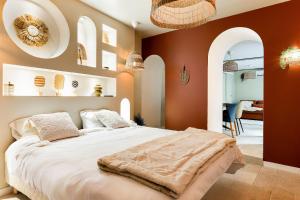 a bedroom with a large bed with orange walls at Suite Marrakech avec jacuzzi privatif Love Room romantique proche Toulouse in Auterive +20 photos