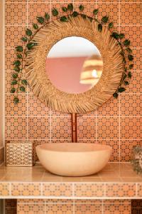 a bathroom with a round mirror and a sink at Suite Marrakech avec jacuzzi privatif Love Room romantique proche Toulouse in Auterive