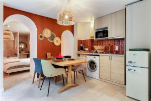 AuteriveにあるSuite Marrakech - Balnéo Privée - Netflixのテーブルと冷蔵庫のあるキッチンとダイニングルーム