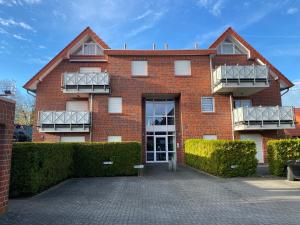 een gebouw van rode baksteen met 2 balkons bij Meeresbrise 14 in Wangerland