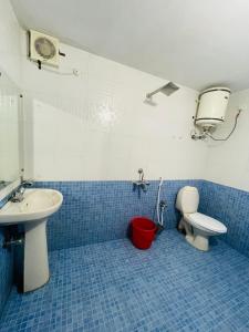 a blue tiled bathroom with a sink and a toilet at Hamlet Beach Villas Alleppey in Alleppey +173 photos