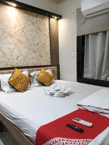 a bed with two remote controls on top of it at Hotel Sun in Bishnupur