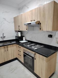 タンジェにあるRiad Salam Tangierの木製のキャビネットとコンロ付きオーブンを備えたキッチン