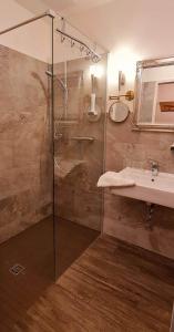 a bathroom with a glass shower and a sink at Hasseröder Burghotel in Wernigerode