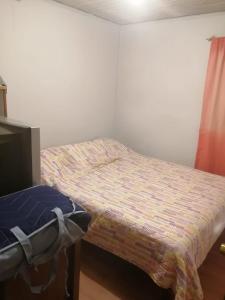 une petite chambre avec un lit dans une pièce dans l'établissement Amplia casa en cartagena, à Carthagène