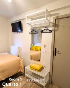 a bedroom with a bed and a mirror at We host in Costa da Caparica