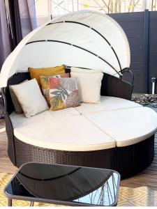 a wicker bed with pillows on top of it at La Cachette Fleurie in Hésingue