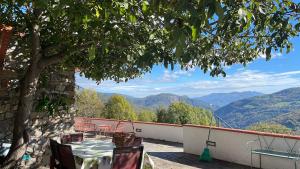 a table and chairs on a balcony with a view of mountains at Total Peace and quiet on the top of the mountain, in Prats-de-Mollo-la-Preste