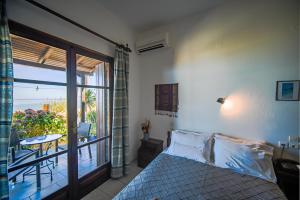 a bedroom with a bed and a balcony with a table at Hotel Hagiati in Chorefto