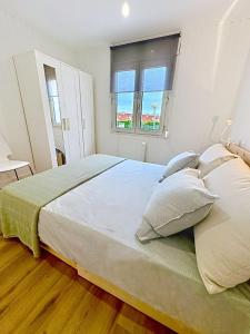 ein Schlafzimmer mit einem großen Bett mit zwei Kissen in der Unterkunft Bajo reformado con terraza en Mogro in Mogro