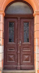 a wooden door with two windows in a brick building at Útulný apartmán v srdci Jihlavy in Jihlava
