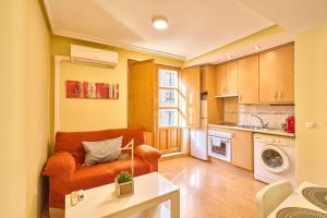 a living room with a couch and a kitchen at San Justo Suites in Salamanca