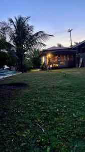 a house with a palm tree in front of a yard at Casa da Prosperidade in Marau +1 photo
