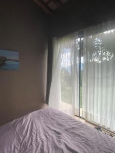 AngelópolisCasa de Campo Cerca a Medellín的一间卧室，里面有一张床和一扇大窗户。