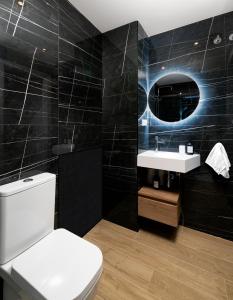 a bathroom with a toilet and a sink and a mirror at Apartamentos La Gringa Centro Gijon II Obra nueva con posibilidad de Parking in Gijón