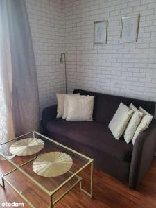 un soggiorno con un divano e un tavolo di vetro di Oliwa Business & Relax a Danzica