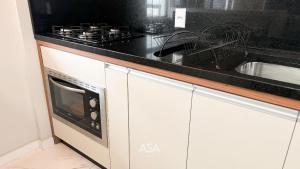 a kitchen with a sink and a stove at ASA | Pé na Areia | Frente-Mar Meia Praia | 2 Qtos in Navegantes +6 photos