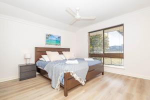 een witte slaapkamer met een bed en een raam bij Jurien Haven in Jurien Bay