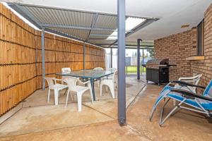 een terras met een tafel, stoelen en een grill bij Jurien Haven in Jurien Bay