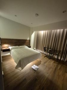 a bedroom with a large bed and a table at Hotel Zaniah in Huancayo
