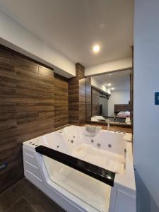 a large white bath tub in a bathroom with wooden walls at Hotel Zaniah in Huancayo