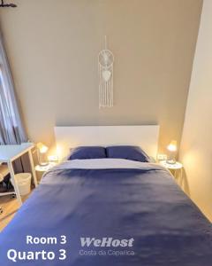 a bedroom with a large bed with blue sheets at We host in Costa da Caparica +21 photos