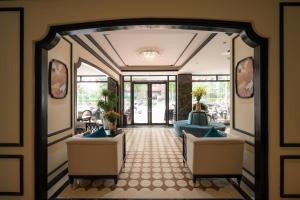 Un vestíbulo con dos sillas azules y una puerta en San Hotel & Pool, en Hanói