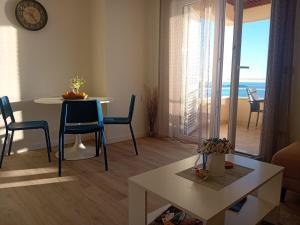 a living room with a table and chairs with a view of the ocean at Apartmani NIKA in Dubrovnik