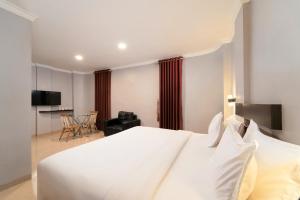 a bedroom with a white bed and a living room at Barelang Hotel Nagoya Batam in Nagoya +77 photos