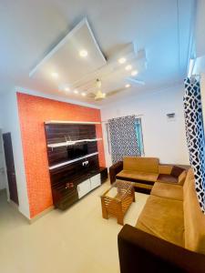 a living room with a couch and a television at KK Residences in Madikeri